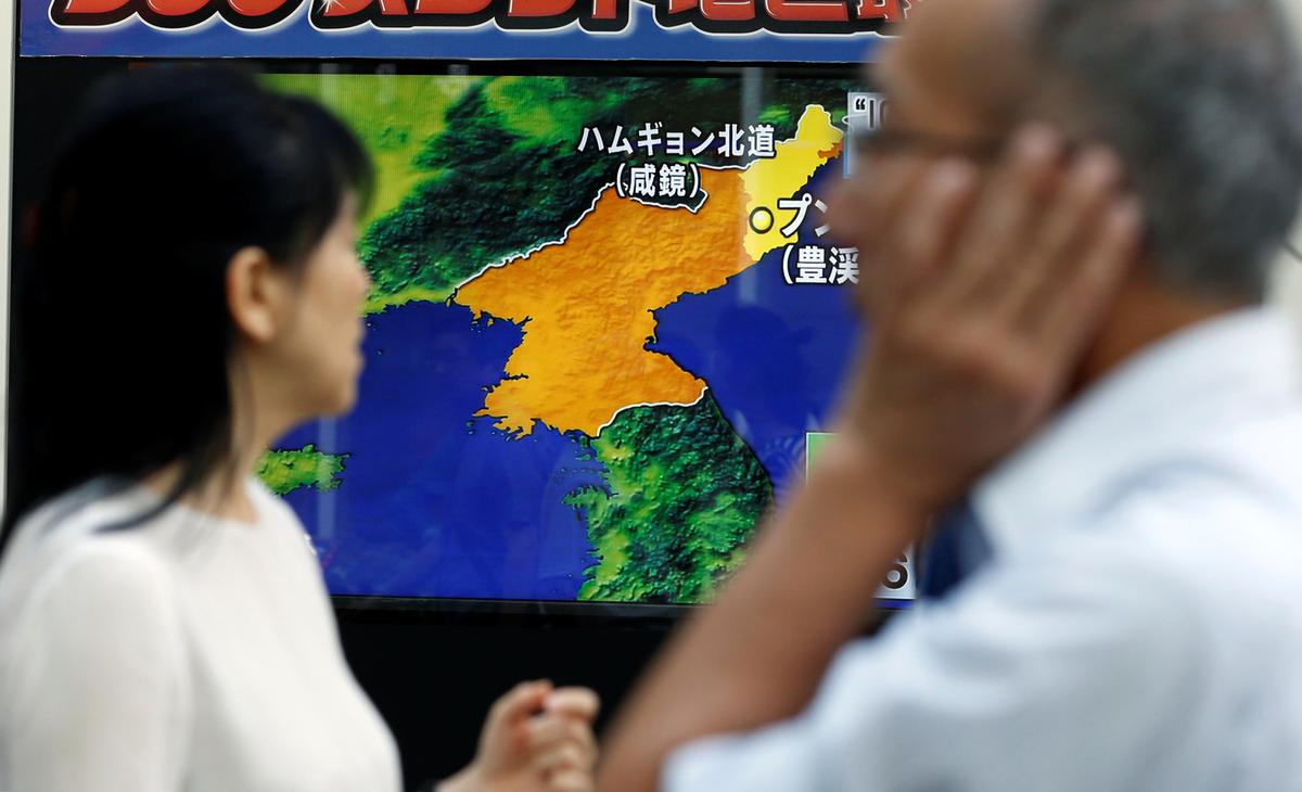 People walk past a street monitor showing a news report about North Korea's nuclear test, in Tokyo, Japan on Sept. 3, 2017. (REUTERS/Toru Hanai)
