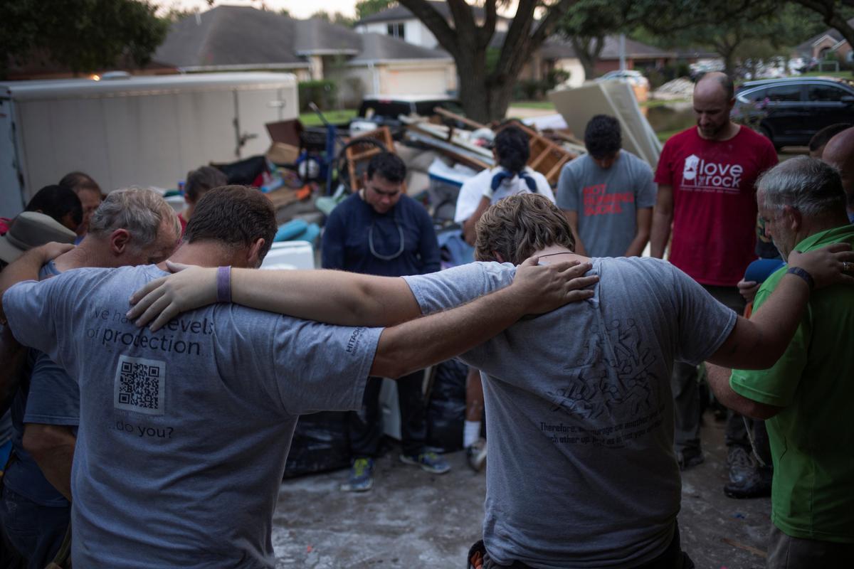 Samaritans pray after helping clear furniture from the flooded house of a neighbor in the aftermath of Tropical Storm Harvey in Houston, Texas on Sept. 3, 2017. (REUTERS/Adrees Latif)