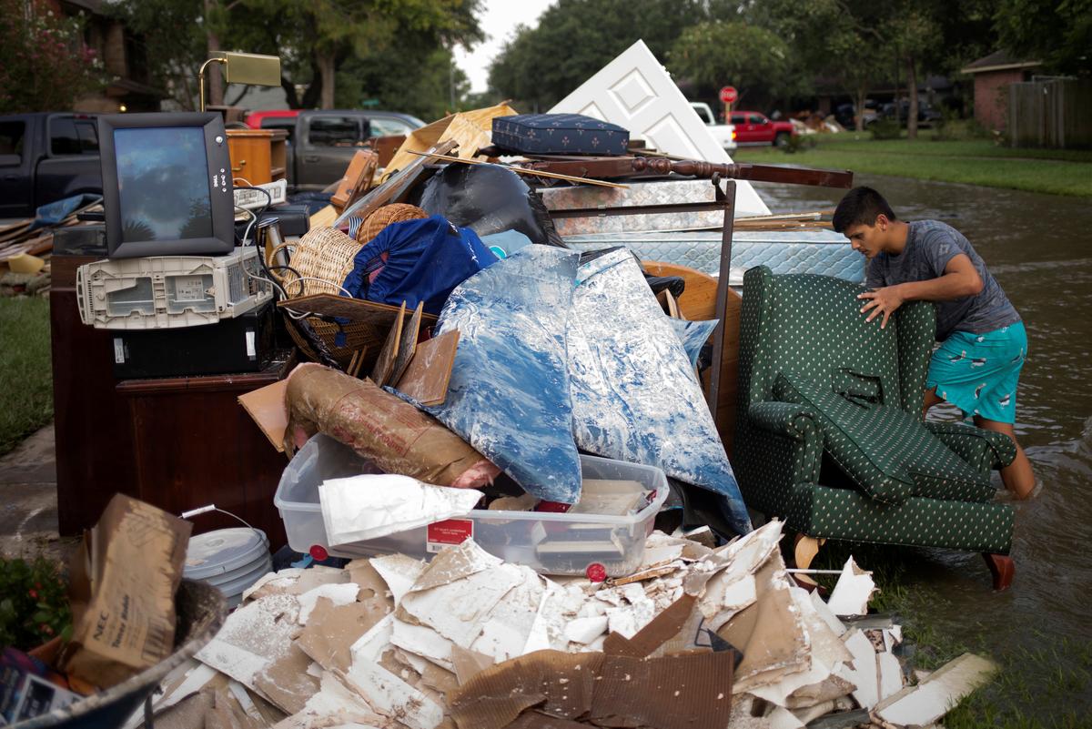 Isaac Zermeno discard furniture from the house of a neighbor who was left flooded from Tropical Storm Harvey in Houston, Texas on Sept. 3, 2017. (REUTERS/Adrees Latif)