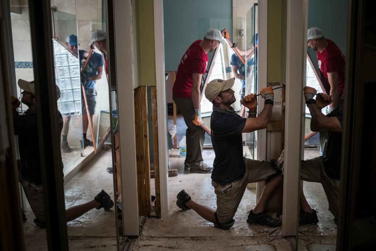 Ben Hyman and other samaritans help clear debris from the house of a neighbor which was left flooded from Tropical Storm Harvey in Houston, Texas on Sept. 3, 2017. (REUTERS/Adrees Latif)