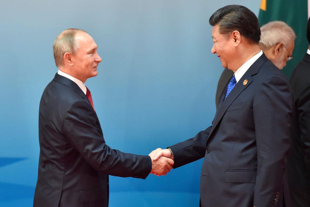 Chinese President Xi Jinping (R) and Russian President Vladimir Putin (L) shake hands before the group photo session at the Dialogue of Emerging Market and Developing Countries on the sidelines of the 2017 BRICS Summit in Xiamen, southeastern China's Fujian Province on September 5, 2017. (KENZABURO FUKUHARA/AFP/Getty Images)