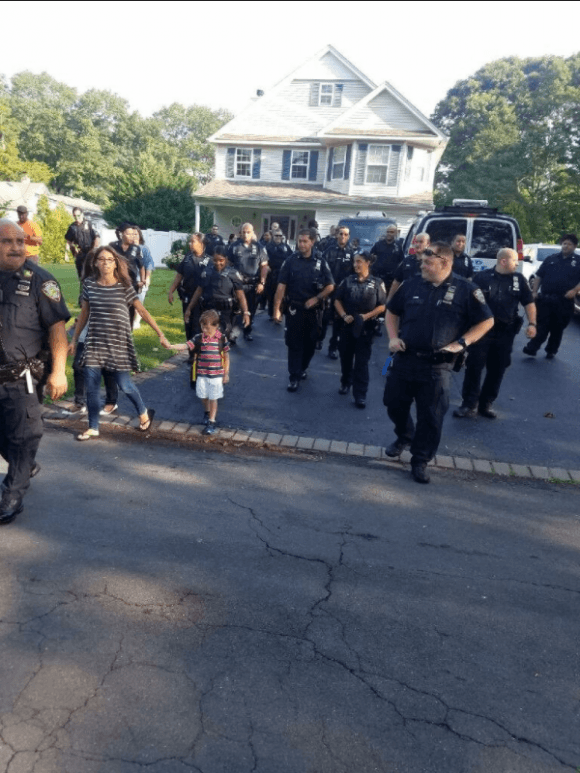 New York police officers from a precinct in the Bronx accompany Austin, son of slain Sgt. Paul Tuozzolo, to his first day of school. (NYPD/Twitter)