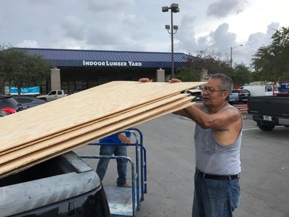 Jerry Garcia, 70, a retired mechanic, loads one of the 20 sheets of plywood he is taking home to prepare for Hurricane Irma at a home supply store in Oakland Park, Florida, September 5, 2017. (Reuters/Bernie Woodall)