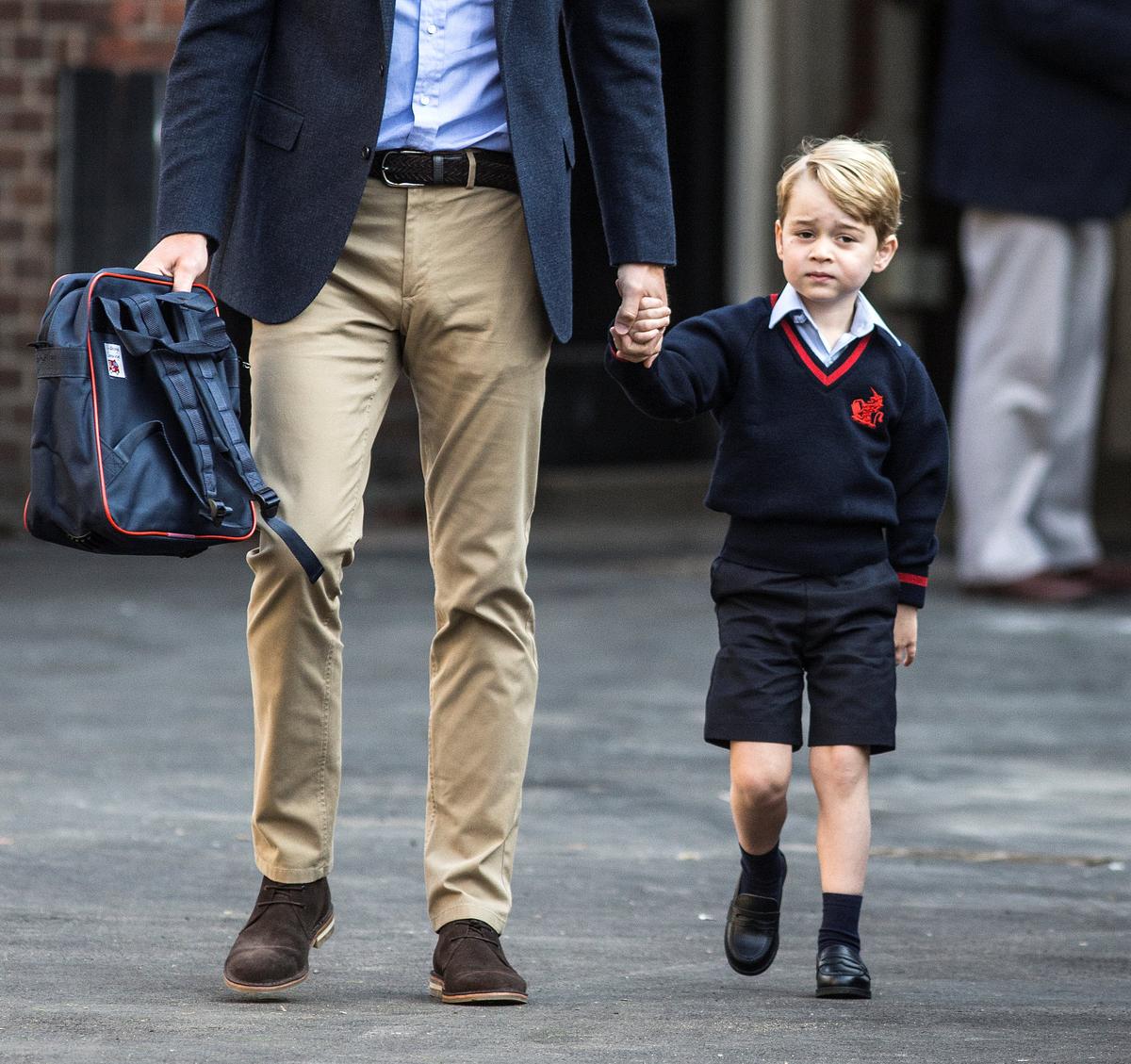 Prince George holds his father Britain's Prince William's hand as he arrives on his first day of school at Thomas's school in Battersea, London on Sept. 7, 2017. (REUTERS/Richard Pohle/Pool)