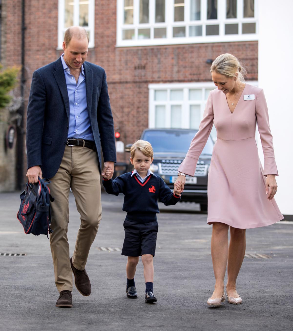 Helen Haslem, head of the lower school and Britain's Prince William hold Prince George's hands as he arrives for his first day of school at Thomas's school in Battersea, London, Sept. 7, 2017. (REUTERS/Richard Pohle/Pool)