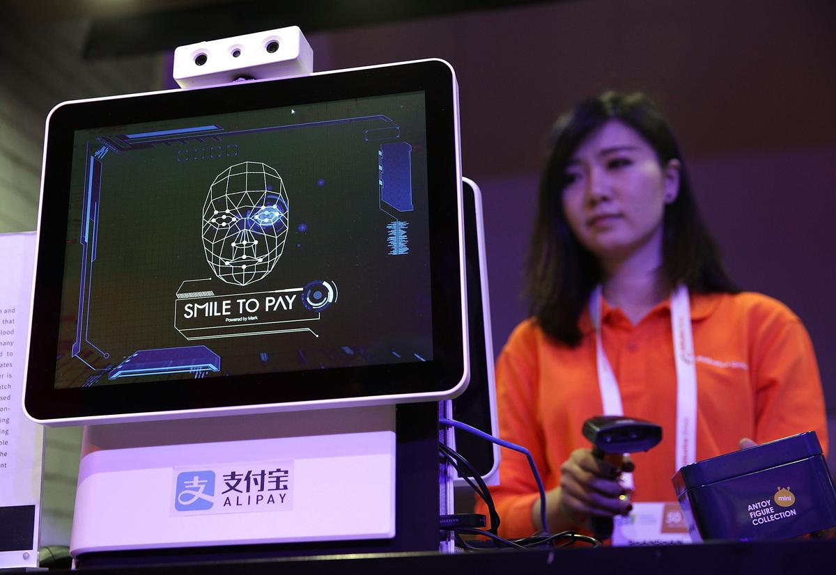 An Alibaba employee demonstrates 'Smile to Pay,' an automatic payment system that authorizes payment via facial recognition, at the Alibaba booth during CES 2017 at the Las Vegas Convention Center on Jan. 5, 2017, in Las Vegas, Nev. (Alex Wong/Getty Images)