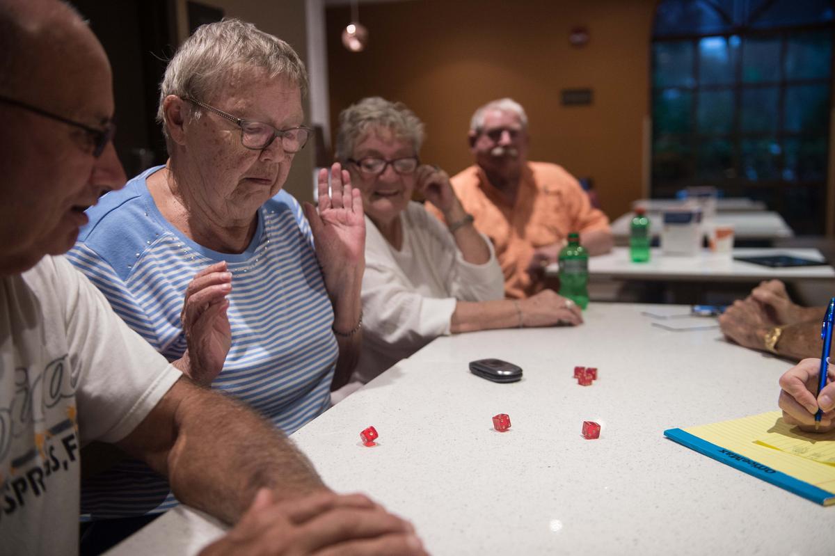 Retirees from nearby a mobile home community play dice in a hotel where they sought shelter in Bonita Springs, Florida as Hurricane Irma begins to hit Florida on Sept. 9, 2017. (NICHOLAS KAMM/AFP/Getty Images)