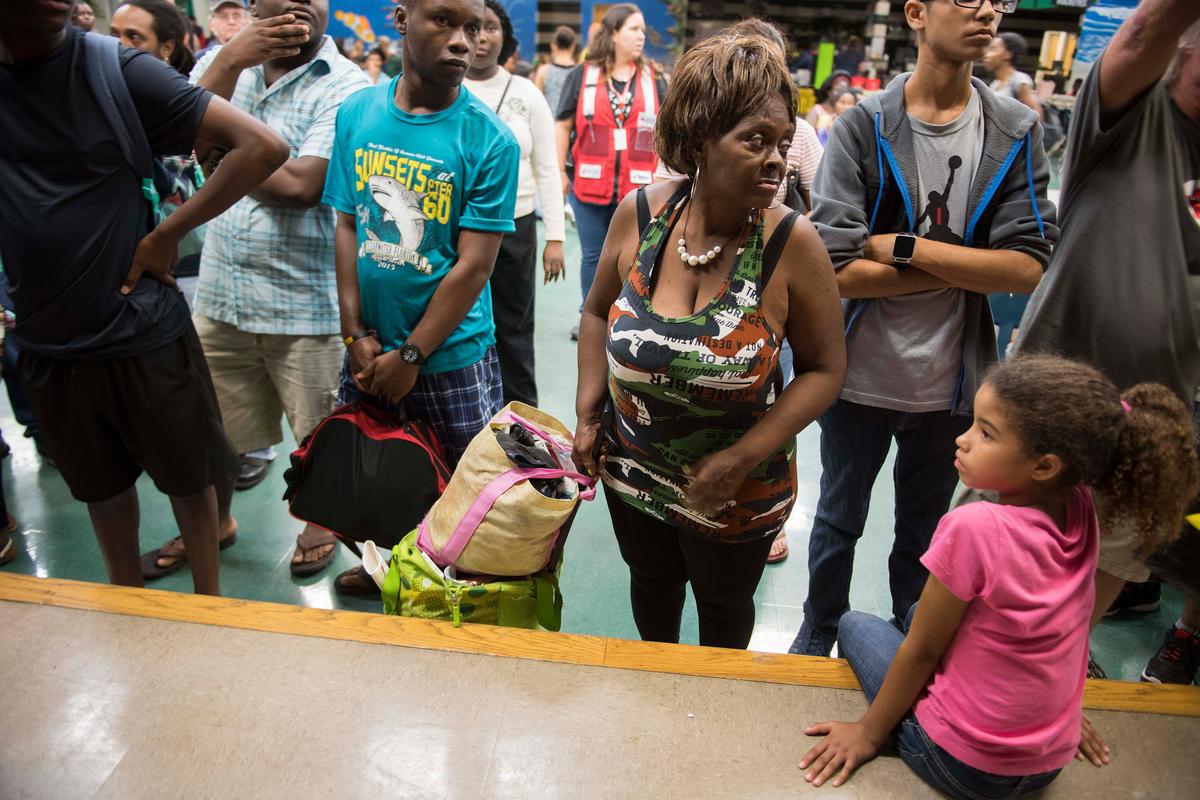 A group of people wait in the cafeteria for room assignments at a shelter within the Pizzo Elementary School in Tampa, Florida where Tampa residents are fleeing the evacuation zones ahead of Hurricane Irma's landfall on Sept. 9, 2017. (JIM WATSON/AFP/Getty Images)