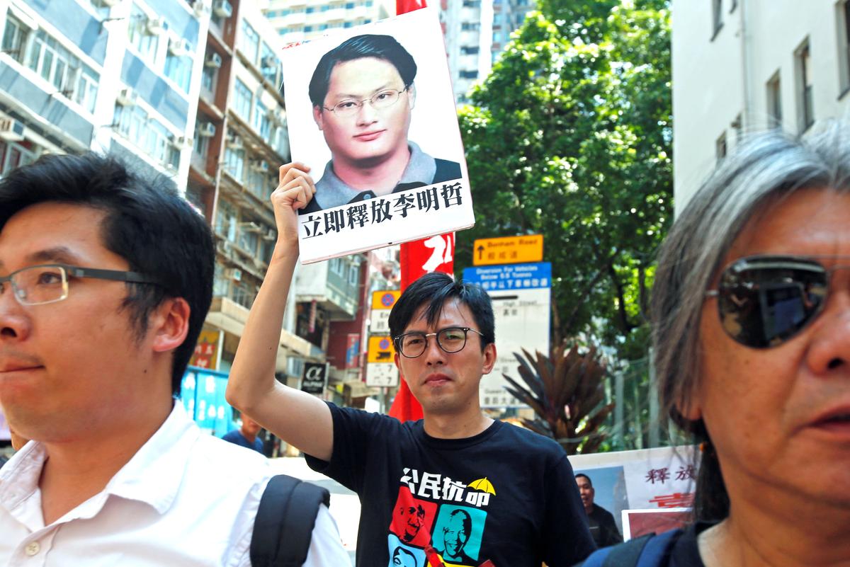 Pro-democracy protesters carry a photo of detained Taiwanese rights activist Lee Ming-Che during a demonstration in Hong Kong, China on Sept. 11, 2017. (REUTERS/Bobby Yip)