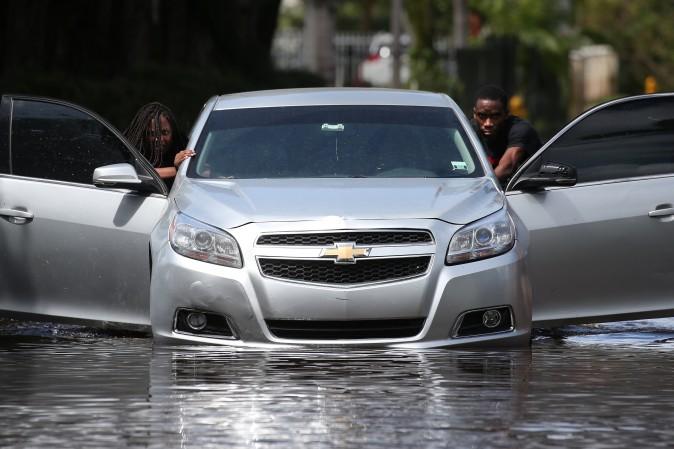 People push a flooded car off a street following Hurricane Irma in North Miami, Fla., on Sept. 11, 2017. (Reuters/Carlo Allegri)
