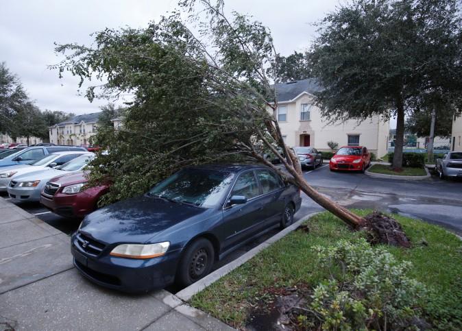 A tree sits atop two cars in the wake of Hurricane Irma making landfall in Kissimmee, Fla., on Sept. 11, 2017. (Gregg Newton/Reuters)