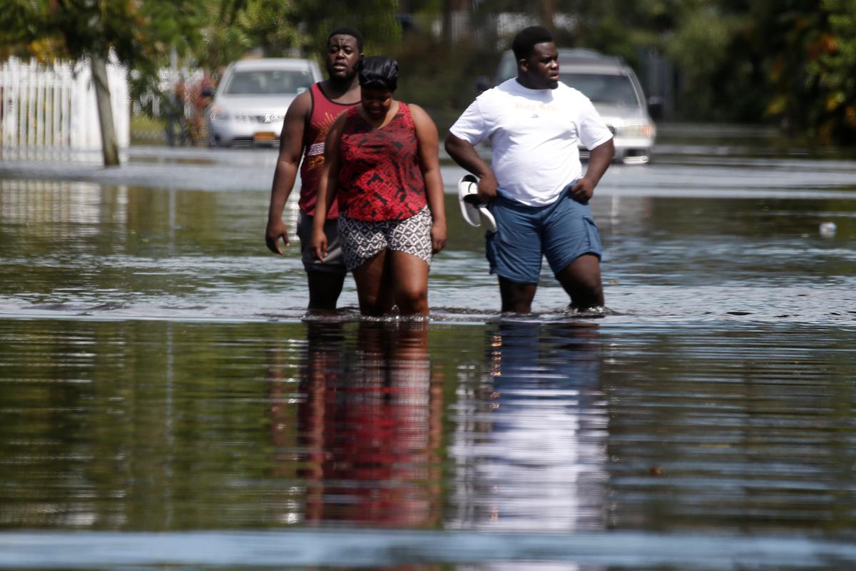People walk on a flooded street following Hurricane Irma in North Miami, Fla., on Sept. 11, 2017. (REUTERS/Carlo Allegri)