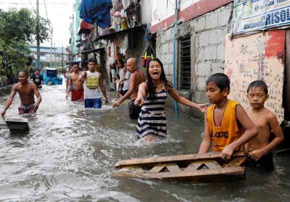 Residents wade in floodwaters in Quezon City, Metro Manila as a storm sweeps across the main Luzon island, Philippines, September 12, 2017.<br/>(Reuters/Dondi Tawatao)