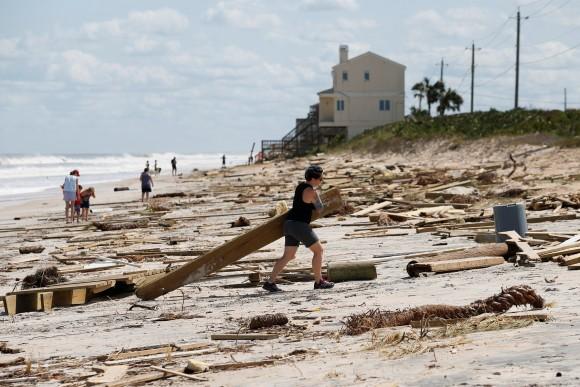 A woman clears debris from the beach after Hurricane Irma passed the area in Ponte Vedra Beach, Florida, U.S., September 12, 2017. (Reuters/Chris Wattie)