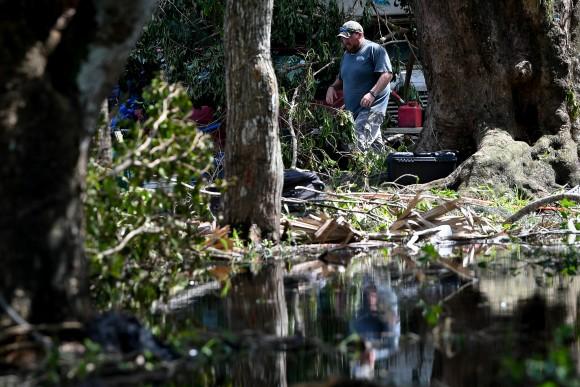Carl Nicholson cleans debris and fallen trees from his flooded yard following Hurricane Irma near Jerome, Florida, U.S., September 12, 2017. (Reuters/Bryan Woolston)