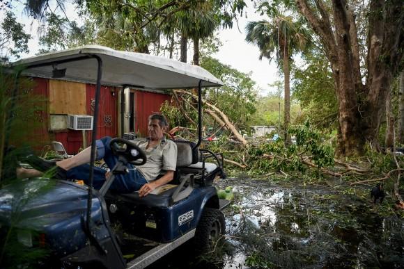 Robert Market, 82, sits in a golf cart in his front yard filled with fallen trees, flood waters, and debris, following Hurricane Irma, near Jerome, Florida, U.S., September 12, 2017. (Reuters/Bryan Woolston)