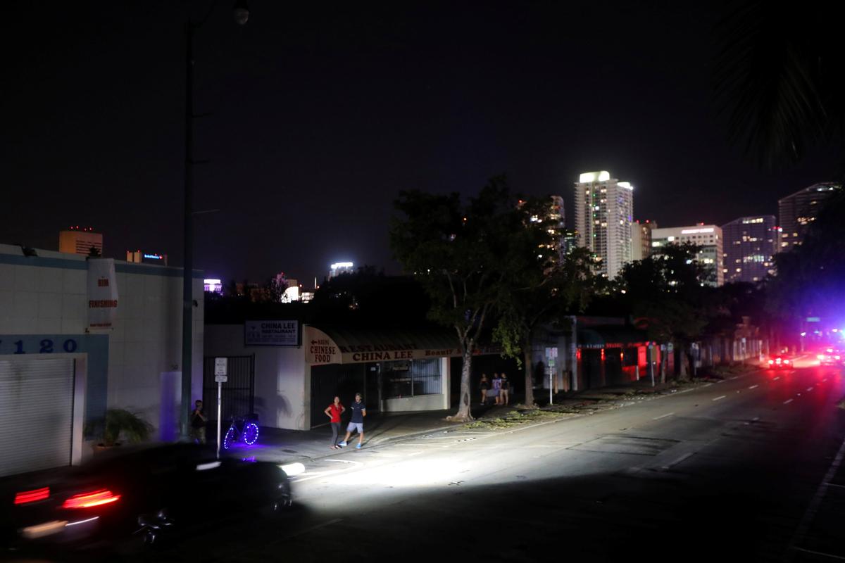 Local residents stand in the darkness as many areas of Miami still without electricity after Hurricane Irma strikes Florida, in Little Havana, Miami, Florida on Sept. 11, 2017. (REUTERS/Carlos Barria)