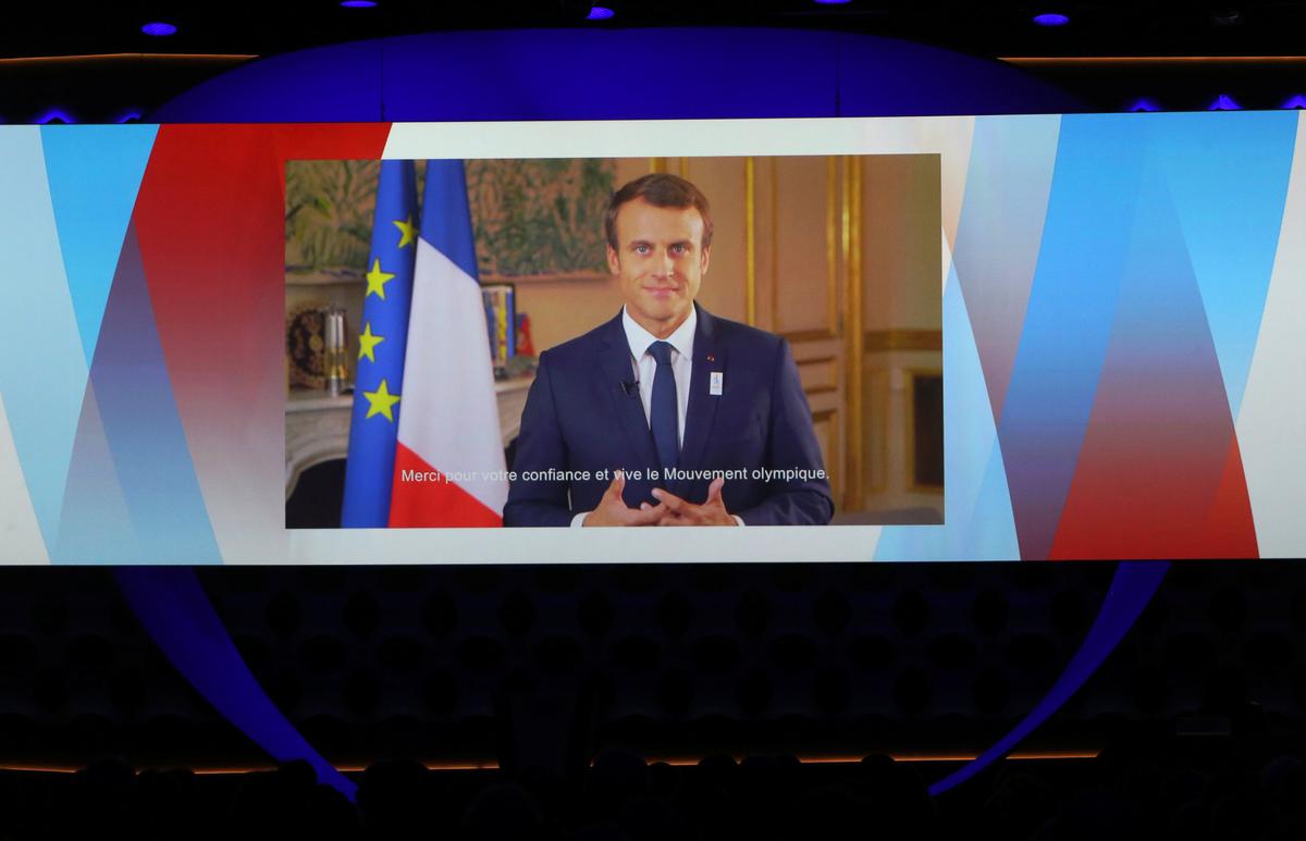 France's President Emmanuel Macron is seen on a screen as he delivers a video speech at the presentation of Paris 2024 at the 131st IOC session in Lima, Peru on Sept. 13, 2017. (REUTERS/Mariana Bazo)