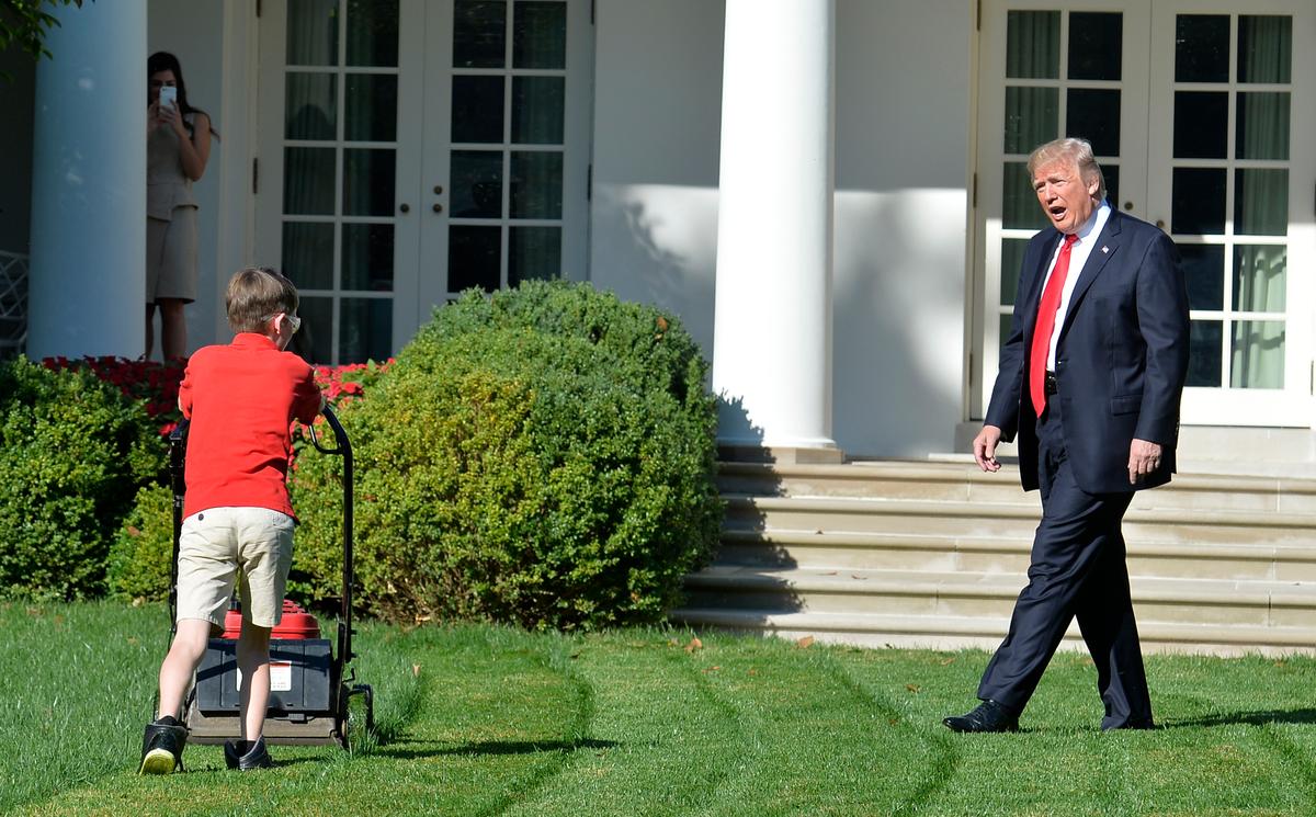 President Donald Trump watches Frank Giaccio, 11, of Falls Church, Virginia, as he mows the lawn in the Rose Garden of the White House in Washington, DC, on Sept. 15, 2017. Giaccio, who has his own lawn mowing business, wrote a letter to the President asking if he could mow the lawn at the White House. (MIKE THEILER/AFP/Getty Images)