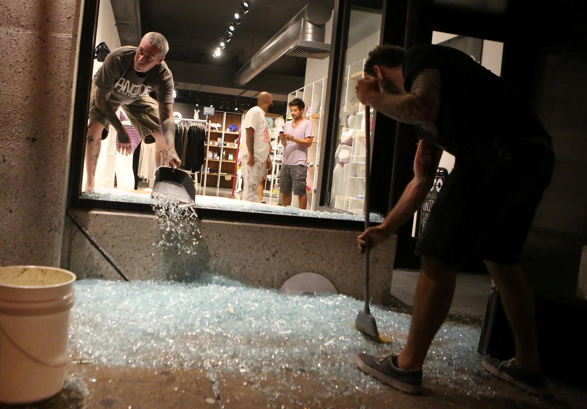 Shopkeepers clean up shattered glass during the second night of demonstrations after a not guilty verdict in the murder trial of former St. Louis police officer Jason Stockley, charged with the 2011 shooting of Anthony Lamar Smith, who was black, in St. Louis, Missouri on Sept. 16, 2017. (REUTERS/Lawrence Bryant)
