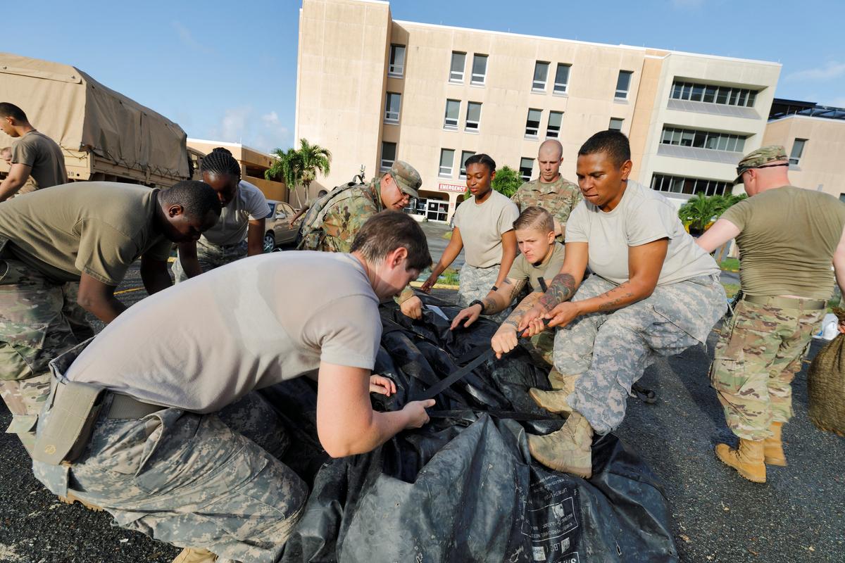 Soldiers from the 602nd Area Support Medical Company secure a portable tent as they break down a field hospital outside the Schneider Regional Medical Center while preparing to evacuate their unit in advance of Hurricane Maria, in Charlotte Amalie, St. Thomas, U.S. Virgin Islands on Sept. 17, 2017. (REUTERS/Jonathan Drake)