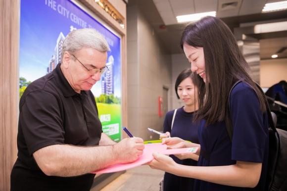 Annie Li, one of the fans greeting Shen Yun, gets an autograph from Milen Nachev, the orchestra's conductor, at the Taipei Songshan Airport on Sept. 19, 2017. (Chen Po-chou/The Epoch Times)