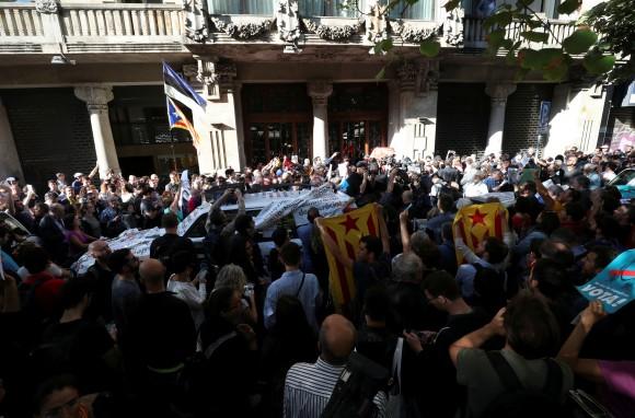 A crowd of protesters gather outside the Catalan region's economy ministry after junior economy minister Josep Maria Jove was arrested by Spanish police during a raid on several government offices, in Barcelona, Spain, September 20, 2017. (Reuters/Albert Gea)