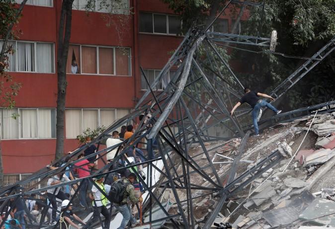 People climb over the debris of a collapsed building after an earthquake hit Mexico City, Mexico, Sept. 19, 2017. (Ginnette Riquelme/Reuters)