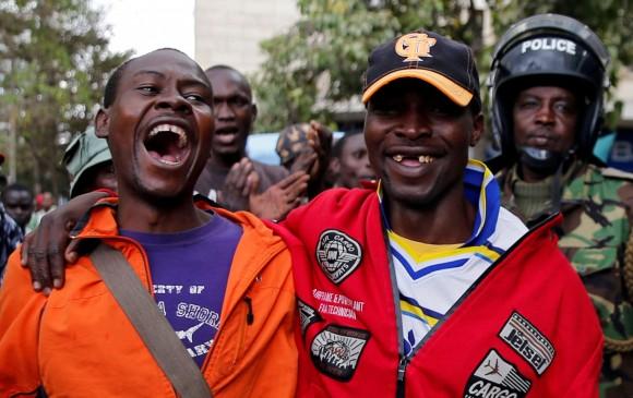 National Super Alliance (NASA) coalition supporters laugh and cheer as they are followed by police near Kenya's Supreme Court In Nairobi, Kenya September 20, 2017. (Reuters/Thomas Mukoya)