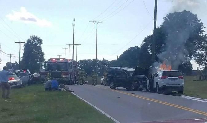 Brandy Guin's burning GMC Terrain SUV (R) and on the other side of the road Sgt. Cory Hinkle lies on the ground by Guin. (Courtesy of Brandy Guin)