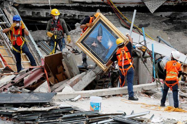 Mexican and international rescue teams remove a painting as they search for survivors in a collapsed building after an earthquake, at Roma neighborhood in Mexico City, on Sept 25 2017. (REUTERS/Carlos Jasso)