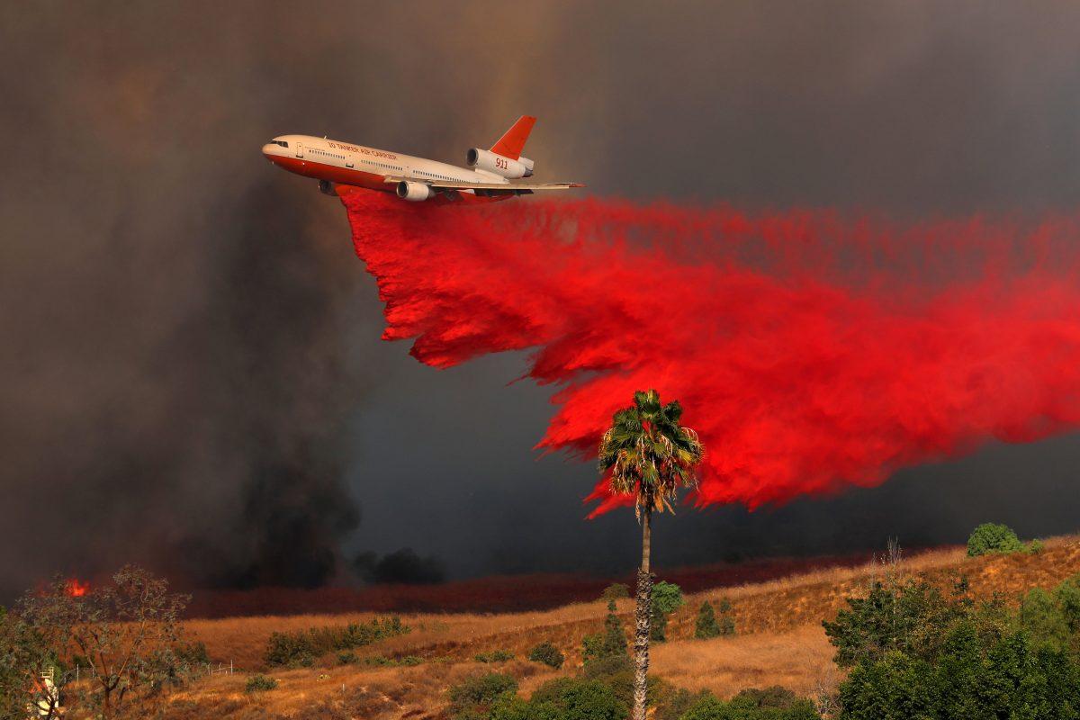 A DC-10 aircraft drops fire retardant on a wind driven wildfire in Orange, California, U.S., Oct. 9, 2017. (Reuters/Mike Blake)