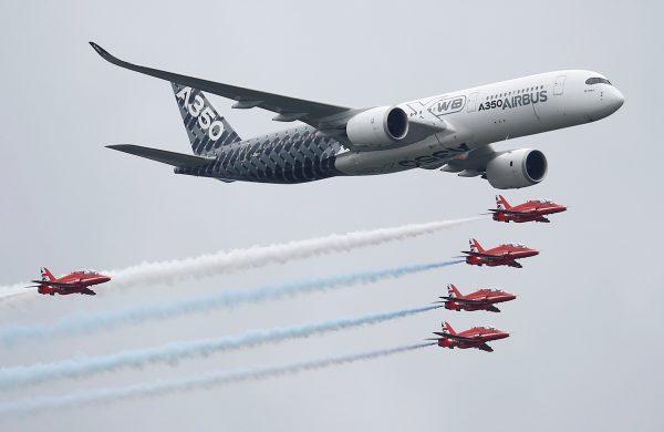 An Airbus A350 aircraft flies in formation with Britain's Red Arrows flying display team at the Farnborough International Airshow in Farnborough, Britain July 15, 2016. (Reuters/Peter Nicholls/File Photo)