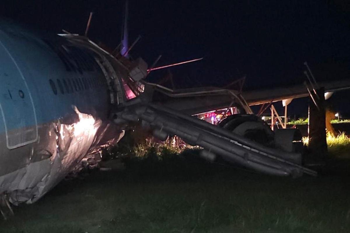 In this photo provided by the Civil Aviation Authority of the Philippines, a damaged portion of the Korean Air Lines Co. plane lies after it overshot the runway at the Mactan Cebu International Airport in Cebu, central Philippines, on Monday, Oct. 24, 2022. (Civil Aviation Authority of the Philippines via AP)