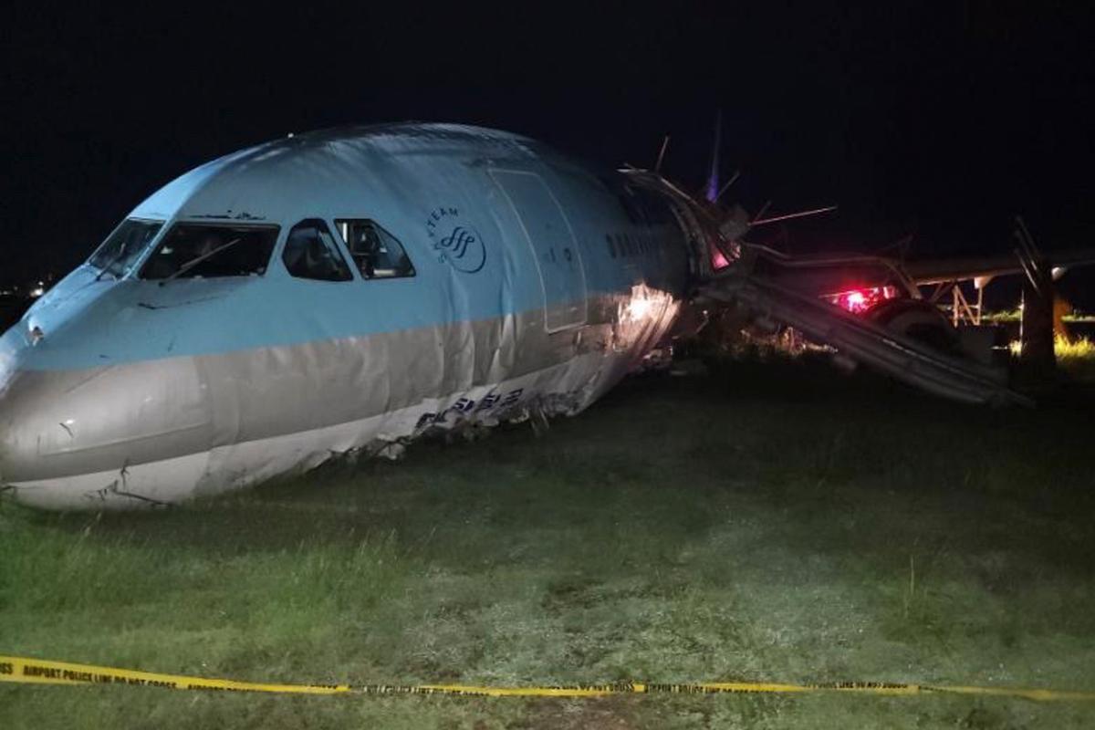 In this photo provided by the Civil Aviation Authority of the Philippines, a damaged portion of the Korean Air Lines Co. plane lies after it overshot the runway at the Mactan Cebu International Airport in Cebu, central Philippines, on Monday Oct. 24, 2022. (Civil Aviation Authority of the Philippines via AP)