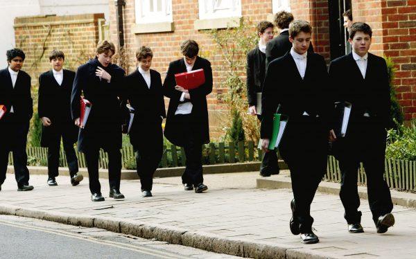 Pupils at Eton College hurry between lessons wearing the school uniform of tailcoats and starched collars, in Eton, England, in this file photo. Eton is one of the most expensive and prestigious private schools in the world. (Graeme Robertson/Getty Images)