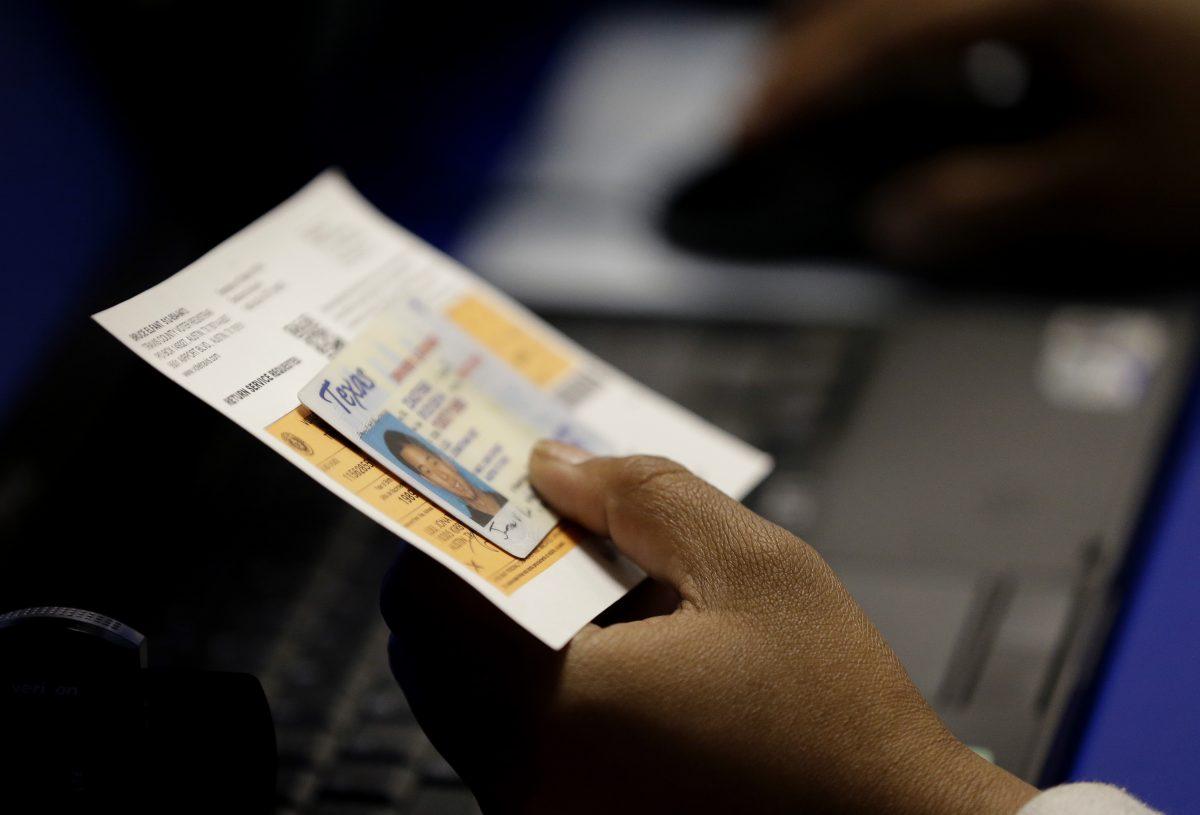 An election official checks a voter's photo identification at an early voting polling site in Austin, Texas, on Feb. 26, 2014. (Eric Gay, File/AP Photo)