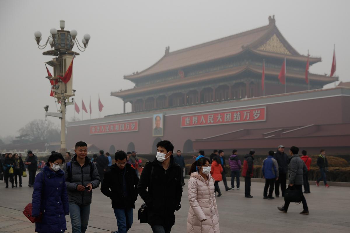 Chinese tourists wear masks on Tiananmen Square during severe pollution in Beijing, China, on Feb. 25, 2014. (Lintao Zhang/Getty Images)