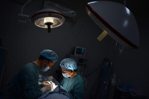 Two doctors perform surgery in southwest China’s Chongqing, on Aug. 9, 2013. A patient received a matching liver and kidney for transplant surgeries within only a month in Tianjin City, according to NTD Television. (Peter Parks/AFP/Getty Images)