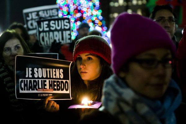People gather to pay to pay tribute to victims of the terrorist attack against the French satirical weekly Charlie Hebdo, at JFK Plaza in Philadelphia, on Jan. 9, 2015. (AP Photo/Matt Rourke)