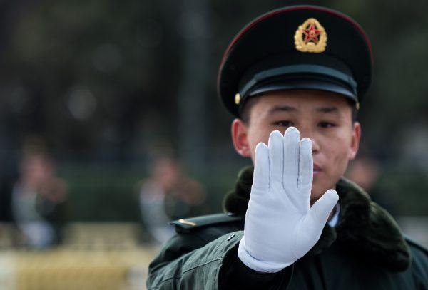 A security guard gestures outside the Great Hall of the People in Beijing during the second day of the National People's Congress on March 6. (Johannes Eisele/AFP/Getty Images)