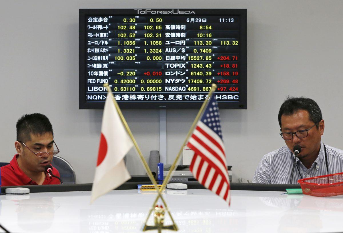 Currency dealers take orders from clients in front of an electronic board showing a variety of exchange rates at Ueda Harlow, a foreign exchange trading company in Tokyo on June 29, 2016. (Shuji Kajiyama/file/AP Photo)