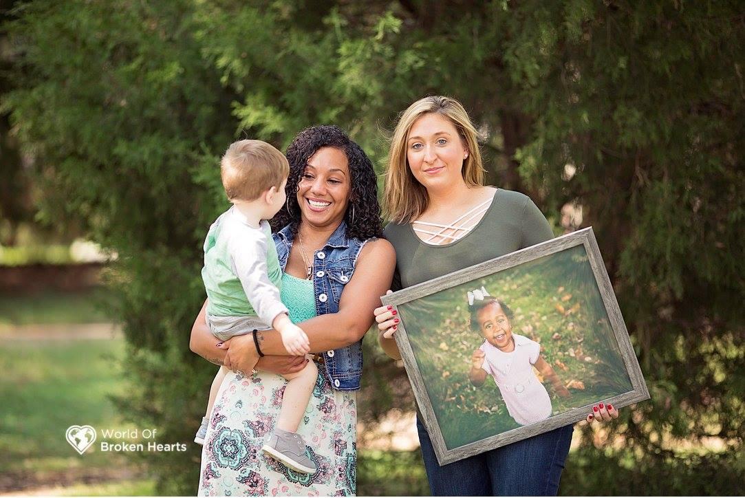 Lacey Tiara Wilcox holds Mason Perkins while his mother Angela holds a picture of Wilcox's late daughter Alaiya in Centennial Park in Nashville, Tenn., on Sept. 25, 2017. Mason received Alaiya's heart in a transplant. (Suha Dabit/World of Broken Hearts)