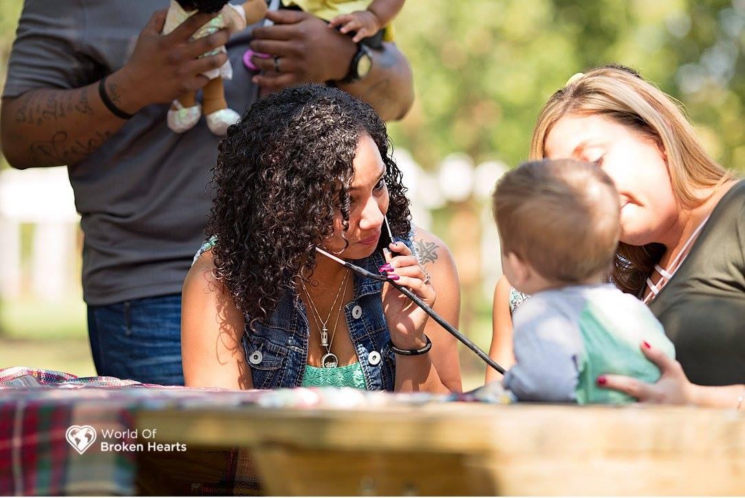 Lacey Tiara Wilcox listens to the heartbeat of Mason Perkins in Centennial Park in Nashville, Tenn., on Sept. 25, 2017. Mason received the heart of Wilcox's late daughter Alaiya in a transplant. (Suha Dabit/World of Broken Hearts)