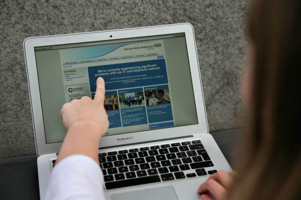 In this file photo a woman points to the website of the NHS: East and North Hertfordshire notifying users of a problem in its network, in London on May 12, 2017. (Daniel Leal-Olivas AFP/Getty Images)