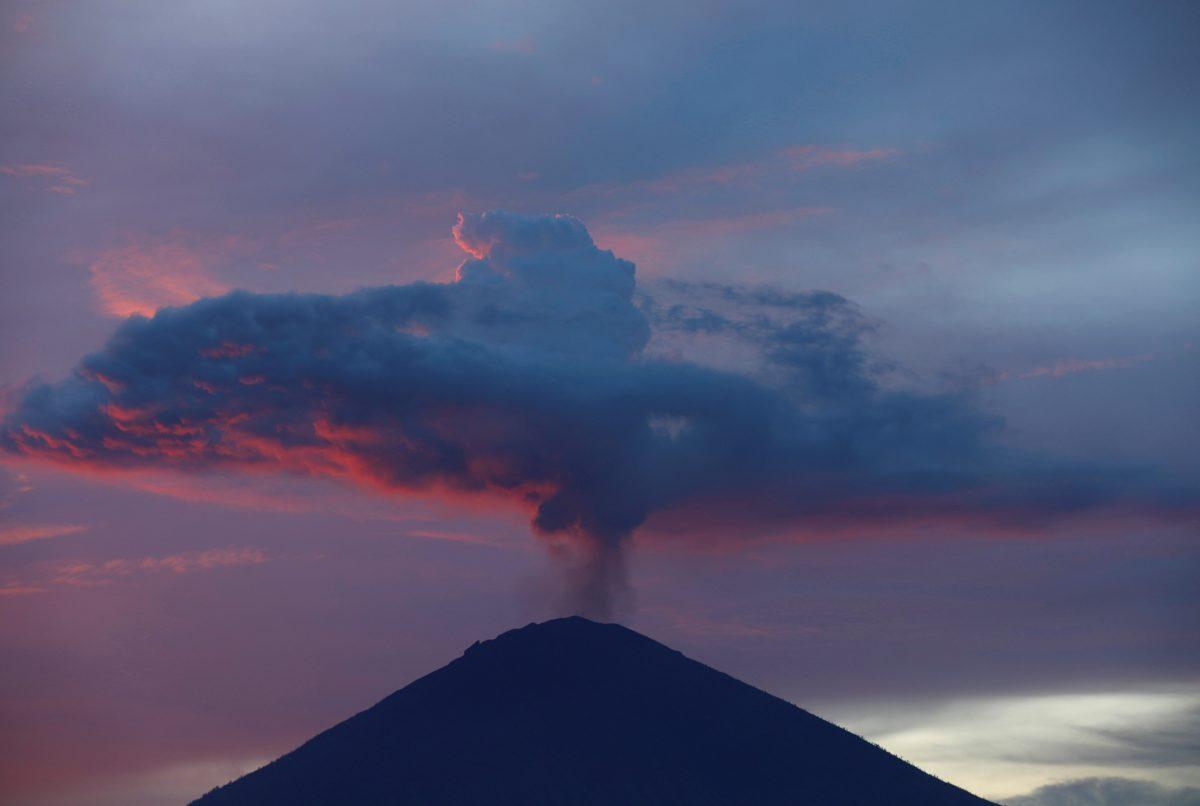 A plume of smoke above Mount Agung volcano is illuminated at sunset as seen from Amed, Karangasem Regency, Bali, Indonesia, Nov. 30, 2017. (Reuters/Darren Whiteside)