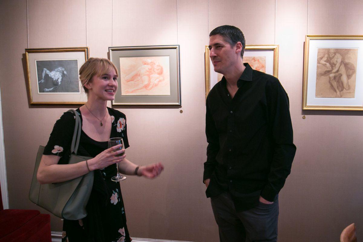 Artists Savannah Tate Cuff and Edward Minoff converse during the opening of "The Unbroken Line" in the Robert Simon Fine Art gallery on May 10, 2018. (Milene Fernandez/The Epoch Times)