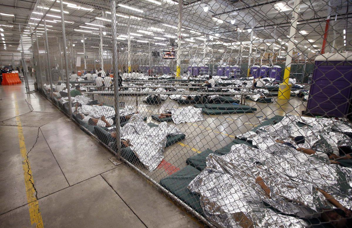 Detainees sleep and watch television in a holding cell where hundreds of mostly Central American immigrant children are being processed and held at the U.S. Customs and Border Protection Nogales Placement Center on June 18, 2014, in Nogales, Arizona. (Ross D. Franklin-Pool/Getty Images)