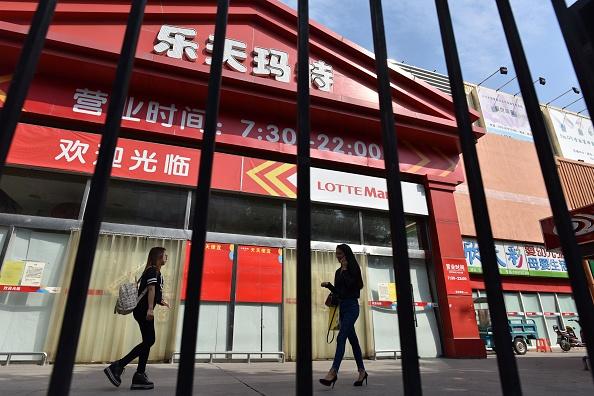 People walk past a closed Lotte Mart store in Beijing on Sept. 15, 2017. The South Korean conglomerate completely withdrew from the Chinese market. (Greg Baker/AFP/Getty Images)
