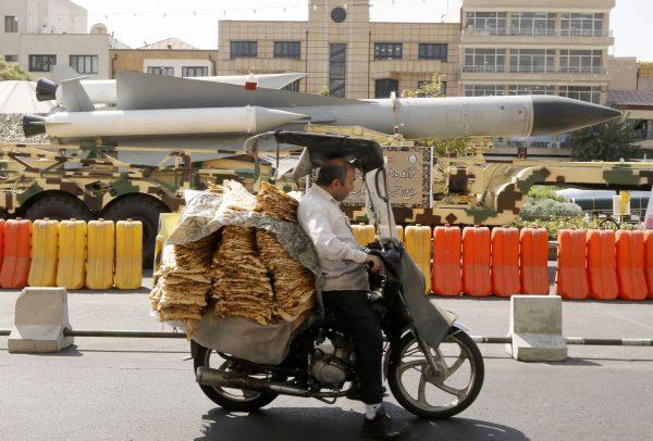 A man rides a scooter past a S-200 surface-to-air missile displayed on Baharestan square in Tehran on September 25, 2017. (Atta Kenare/AFP/Getty Images)